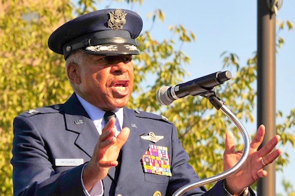 Man in military uniform giving speech behind a podium.