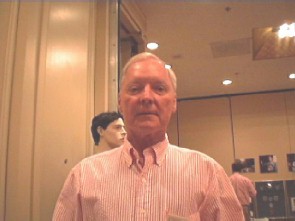 Older man in a red and white striped collared shirt.