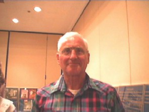 Older man in a a plaid collared shirt.