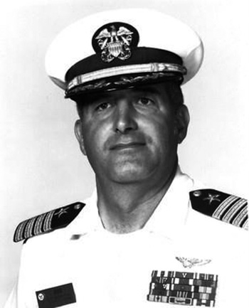 Man in a decorated U.S. Navy suit and cap.