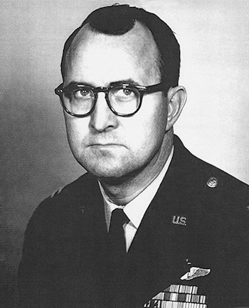 Man wearing glasses dressed in a decorated U.S. Air Force suit. 