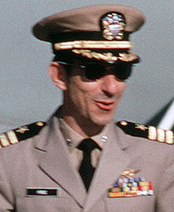 Man in a decorated U.S. Navy suit and cap and sunglasses.