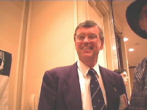 Man smiling in a suit and tie.