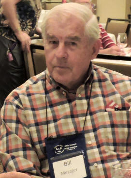 Man in a checkered shirt wearing a name tag.