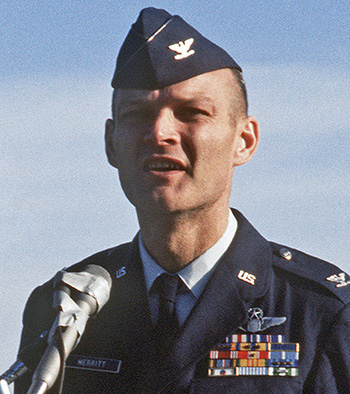 Man in a military uniform giving speech into microphone.