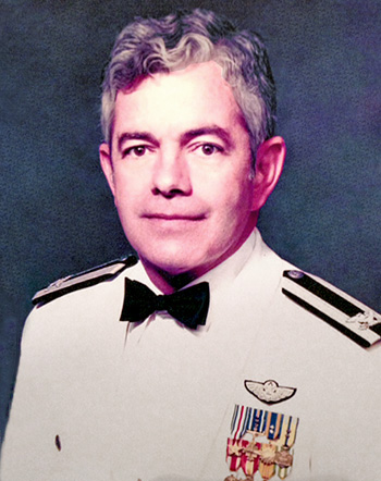 Man in a decorated white U.S. Navy uniform.