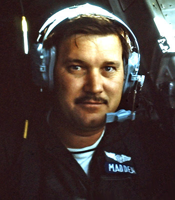 Man in a utility U.S. Air Force uniform wearing a headset.