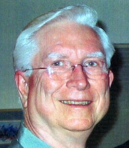 Close up photo of a man wearing glasses smiling.