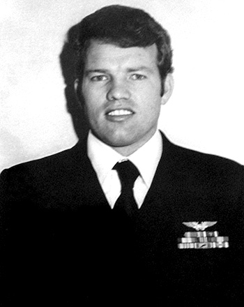 Man in a decorated U.S. Navy suit.