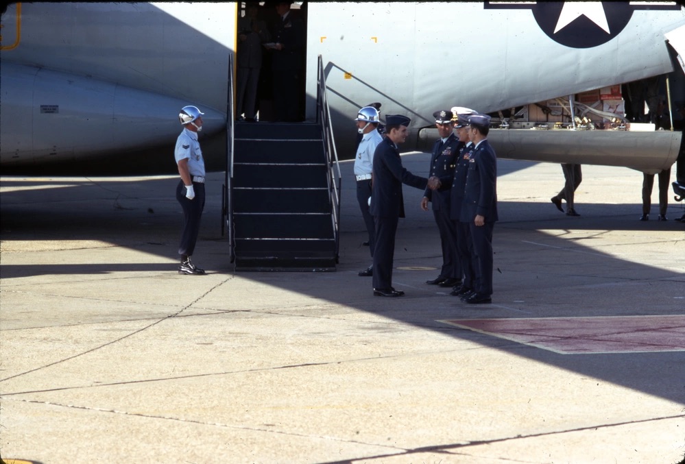 Wide shot of officers taking hands on a tarmac.