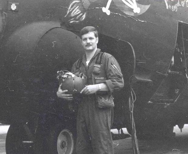 Man in a utility U.S. Air Force uniform holding a helmet.