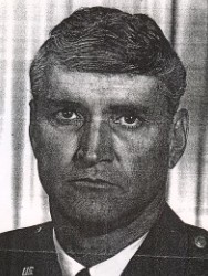 Close up black and white photograph of a man in a suit and tie.