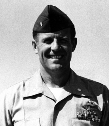 Man in a decorated military collared shirt and cap.