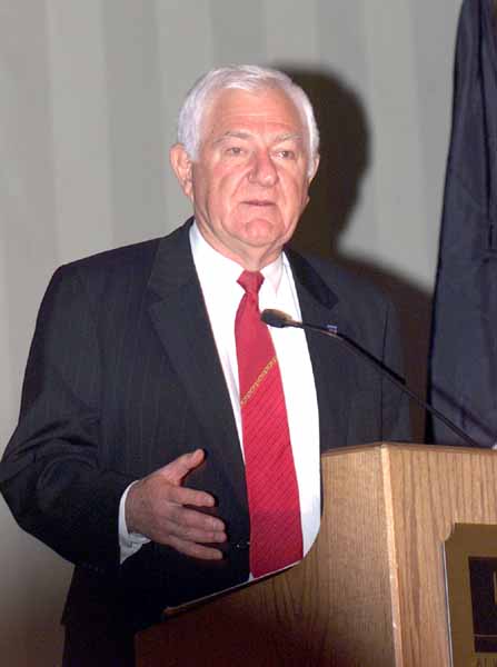 Man in a suit and tie at a podium.