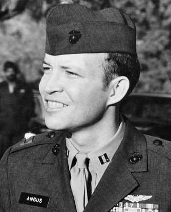 Man in marine corp uniform smiles looking to his left.