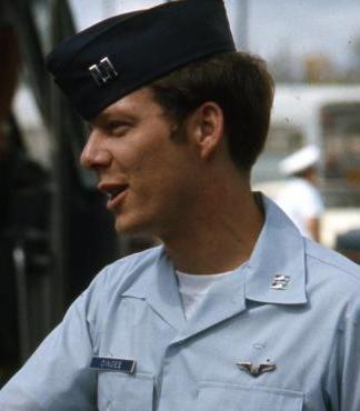 Man in a blue collared shirt and military cap.